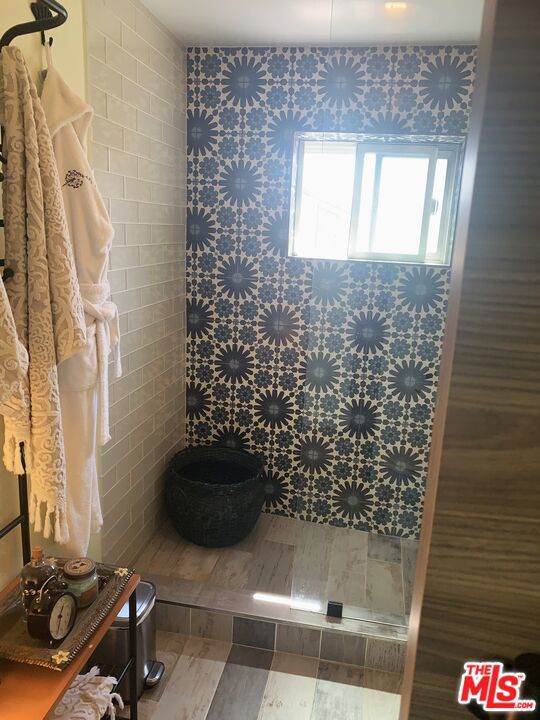 bathroom featuring toilet and a tile shower