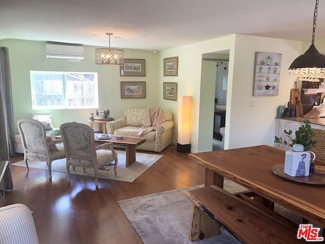 living room with dark hardwood / wood-style floors and a wall unit AC