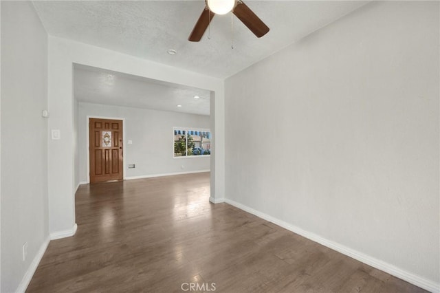 unfurnished room featuring ceiling fan, dark hardwood / wood-style floors, and a textured ceiling