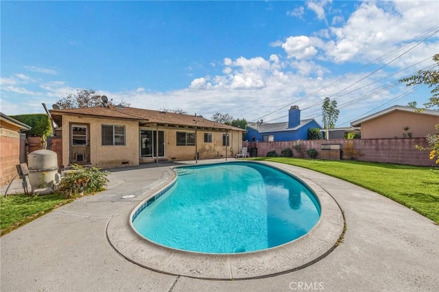 view of swimming pool featuring a yard and a patio area