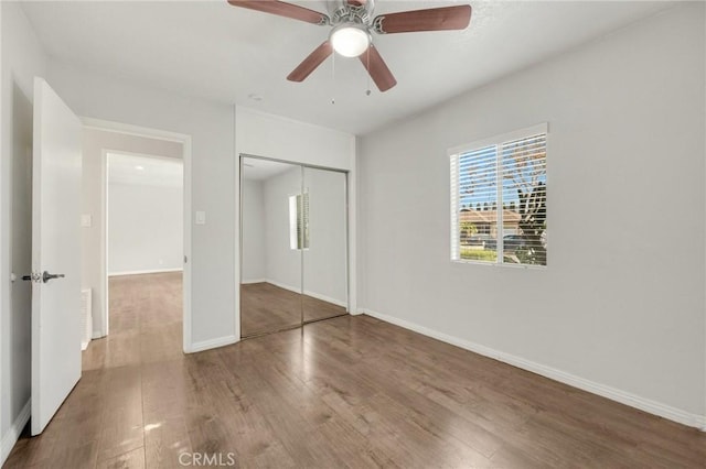 unfurnished bedroom with hardwood / wood-style flooring, ceiling fan, and a closet