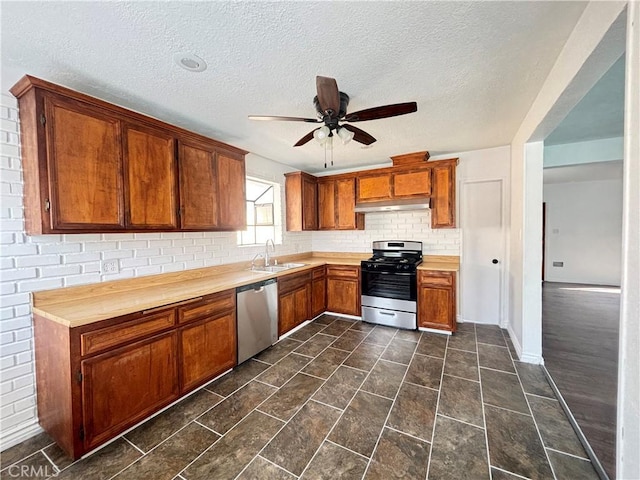 kitchen with sink, wooden counters, ceiling fan, stainless steel appliances, and tasteful backsplash