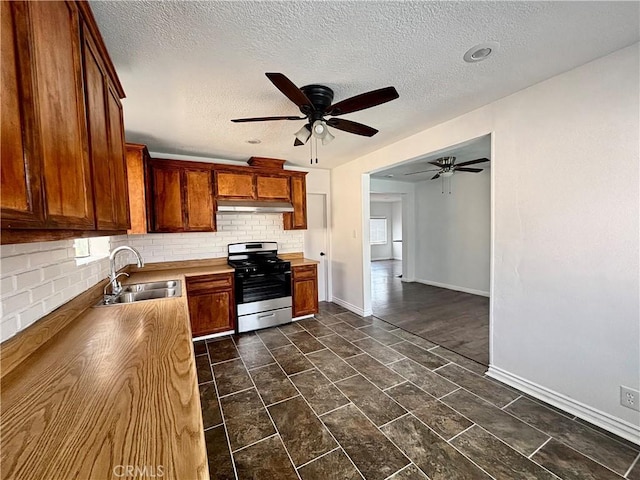 kitchen with sink, ceiling fan, stainless steel range, a textured ceiling, and decorative backsplash