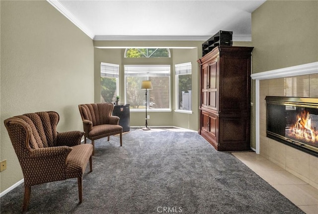 living area with light colored carpet, ornamental molding, and a tile fireplace