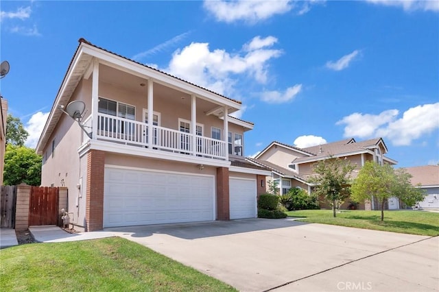 view of front of house featuring a front yard, a balcony, and a garage