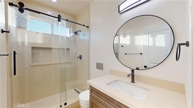 bathroom with vanity, toilet, and a shower with door