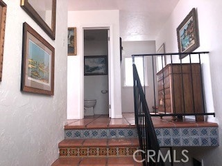 stairway featuring tile patterned flooring