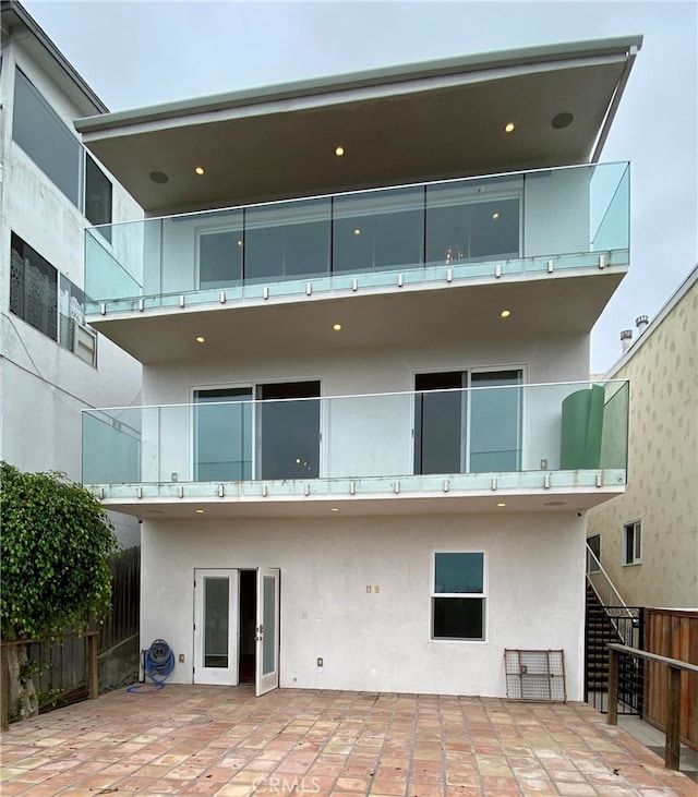 back of house with a balcony and a patio