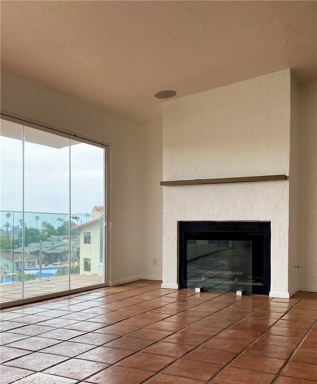 unfurnished living room featuring a textured ceiling and tile patterned flooring