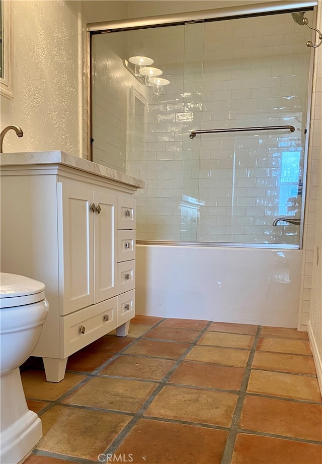 full bathroom featuring shower / bath combination with glass door, toilet, and vanity