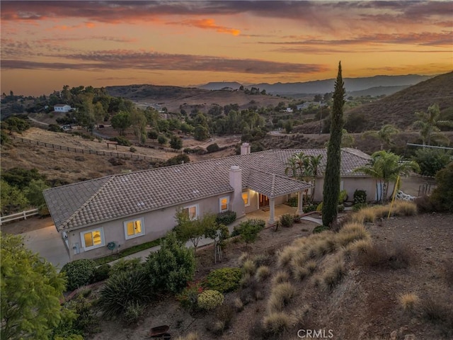 aerial view at dusk featuring a mountain view