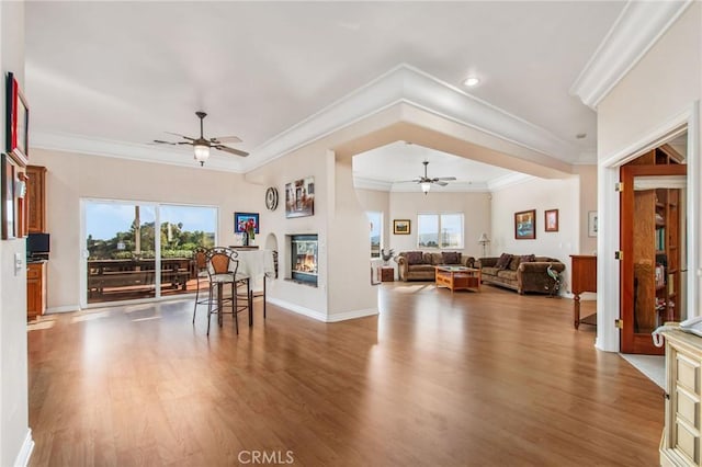 interior space with ceiling fan, wood-type flooring, and crown molding