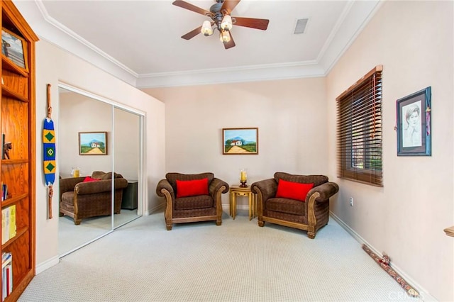 living area with light carpet, ceiling fan, and ornamental molding