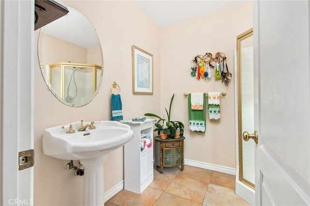 bathroom featuring tile patterned flooring, an enclosed shower, and sink