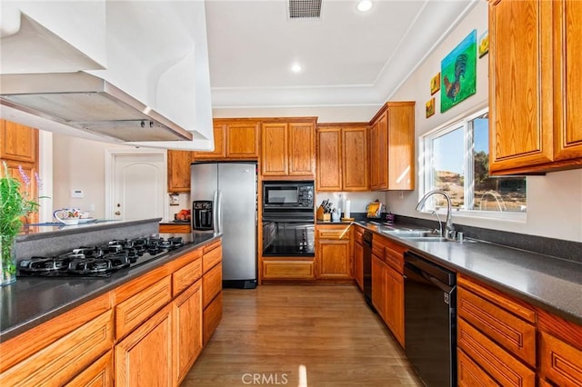 kitchen with black appliances, dark hardwood / wood-style flooring, sink, and exhaust hood