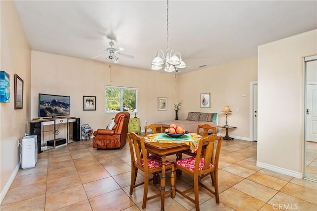 dining area with light tile patterned floors and ceiling fan with notable chandelier