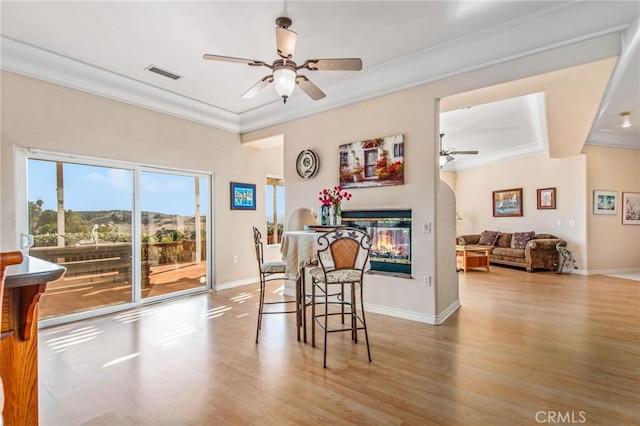 dining area featuring light wood-type flooring, ceiling fan, and ornamental molding