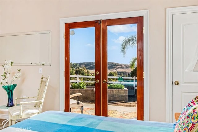 bedroom featuring a mountain view, french doors, and multiple windows