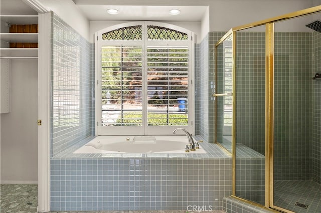 bathroom with shower with separate bathtub and a wealth of natural light