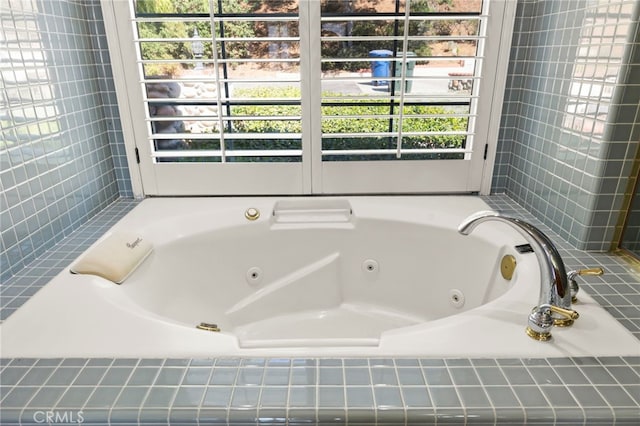 bathroom featuring tiled bath and plenty of natural light