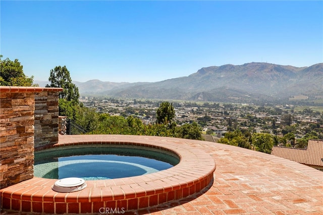 view of pool featuring a mountain view and an in ground hot tub