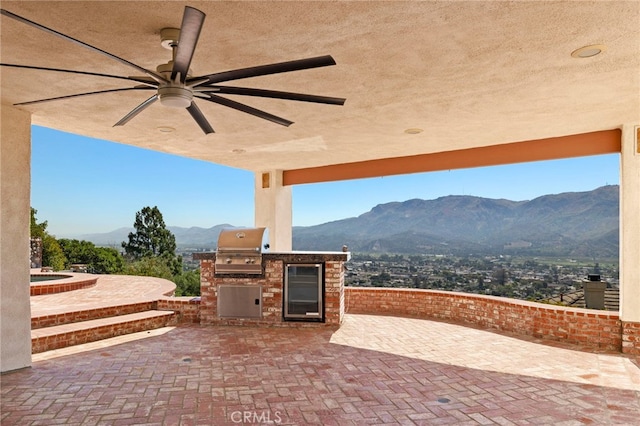 view of patio featuring a mountain view, grilling area, area for grilling, and ceiling fan