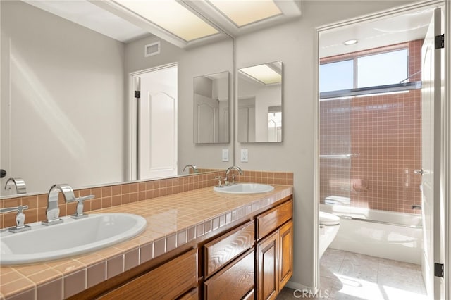 full bathroom featuring combined bath / shower with glass door, tile patterned floors, vanity, and toilet