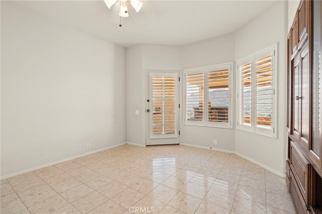 tiled empty room featuring ceiling fan