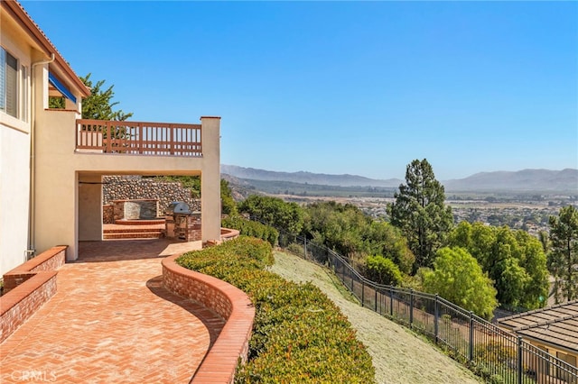 view of yard with a mountain view, a patio, and a balcony