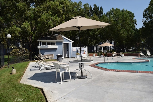 view of swimming pool with an outbuilding and a patio area