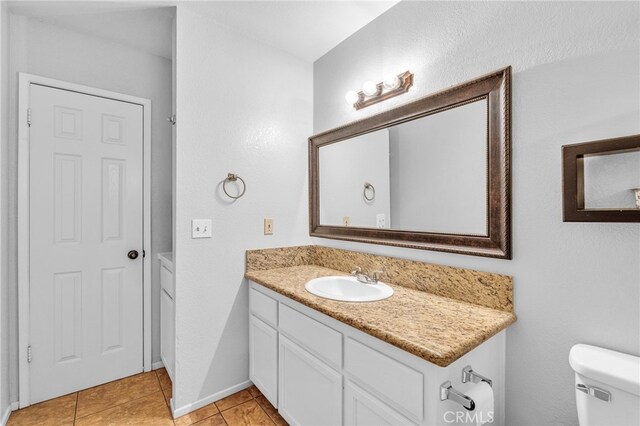 bathroom featuring tile patterned flooring, vanity, and toilet