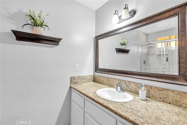 bathroom with walk in shower and vanity