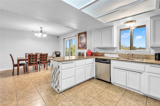 kitchen featuring white cabinets, kitchen peninsula, stainless steel dishwasher, sink, and a chandelier