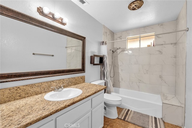 full bathroom featuring vanity, a textured ceiling, tiled shower / bath combo, tile patterned flooring, and toilet