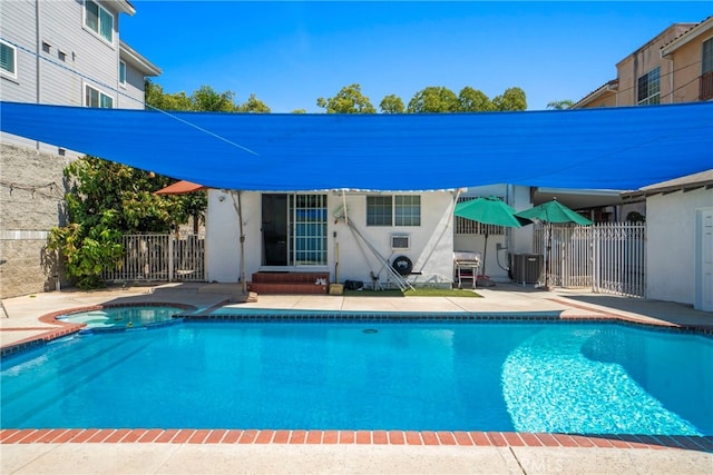 view of swimming pool featuring a patio, an in ground hot tub, and central air condition unit