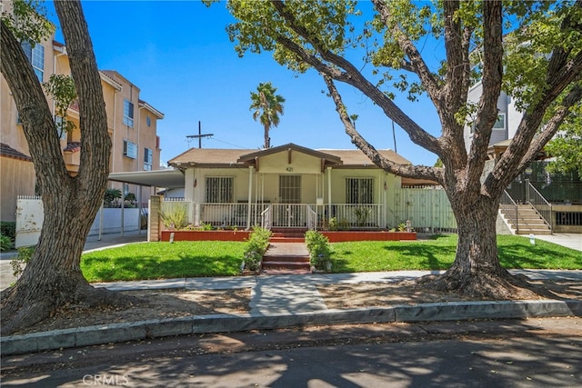 view of front of home with a front yard, covered porch, and a carport