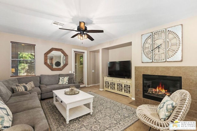 carpeted living room with ceiling fan and a fireplace