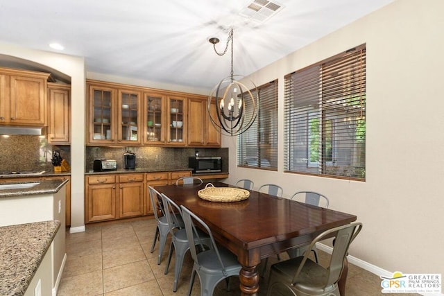 tiled dining space with a chandelier