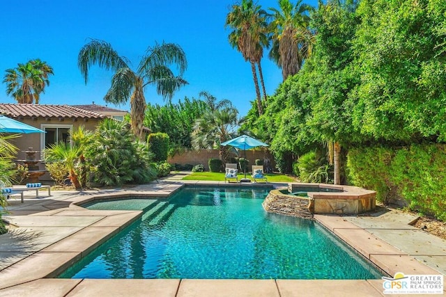 view of pool with a patio and an in ground hot tub