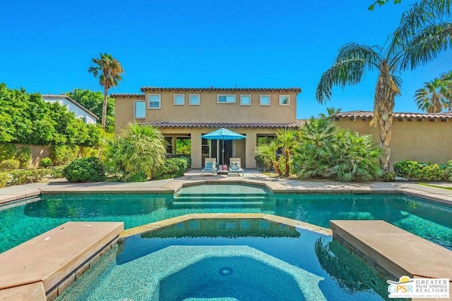 view of pool with an in ground hot tub and a patio area