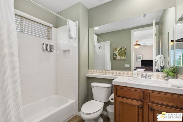 full bathroom featuring ceiling fan, vanity, shower / bath combo with shower curtain, and toilet