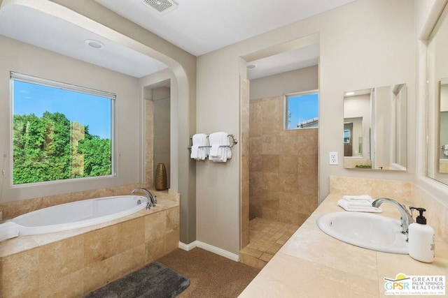 bathroom with shower with separate bathtub, vanity, tile patterned floors, and a wealth of natural light