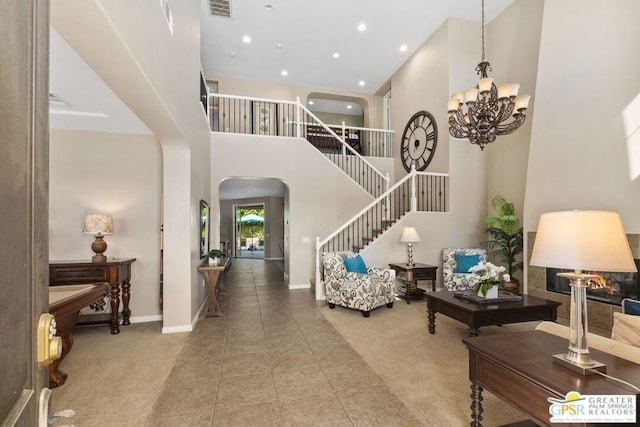 interior space with a notable chandelier, a multi sided fireplace, and a high ceiling