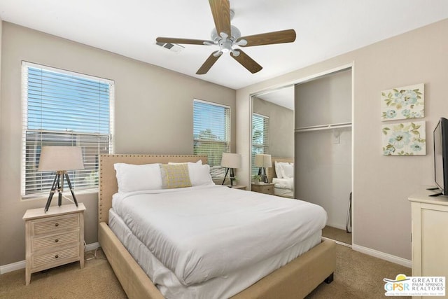 carpeted bedroom with ceiling fan, a closet, and multiple windows