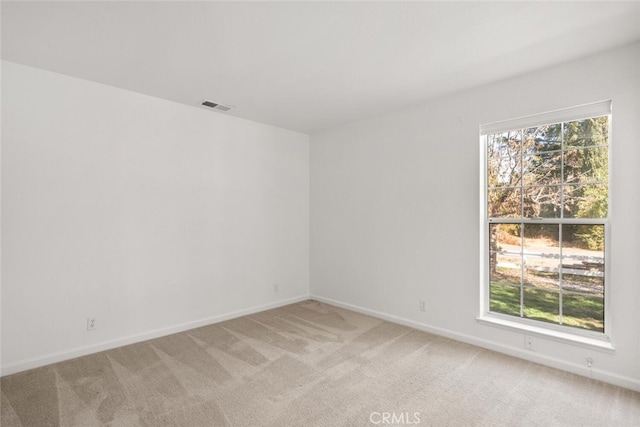 unfurnished room with a wealth of natural light and carpet