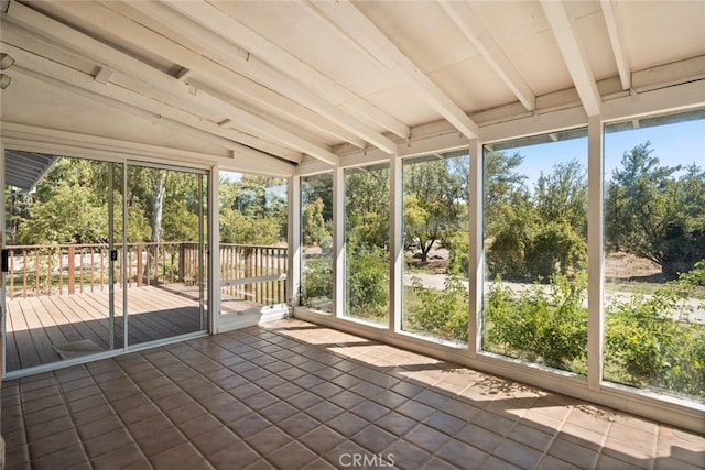 unfurnished sunroom featuring vaulted ceiling with beams