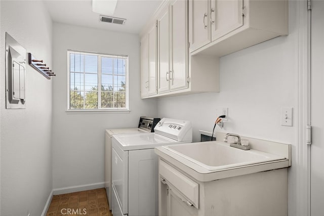 clothes washing area with separate washer and dryer, sink, cabinets, and wood-type flooring