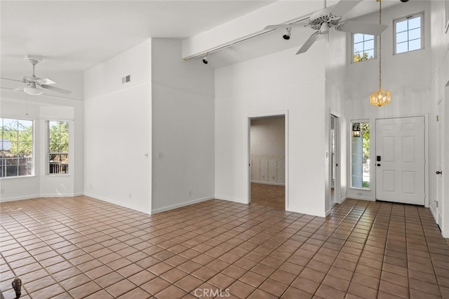 interior space with tile patterned floors, plenty of natural light, high vaulted ceiling, and beamed ceiling