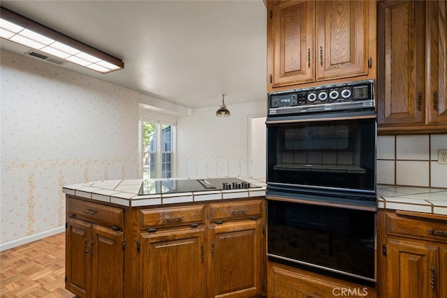 kitchen featuring tile countertops, parquet floors, and black appliances