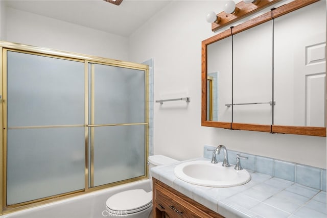 full bathroom with combined bath / shower with glass door, vanity, and toilet